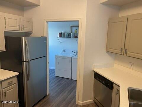 kitchen with appliances with stainless steel finishes, white cabinetry, sink, washing machine and clothes dryer, and dark wood-type flooring