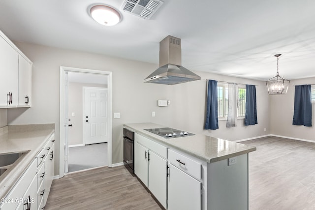 kitchen featuring white cabinetry, pendant lighting, light wood-type flooring, black appliances, and extractor fan