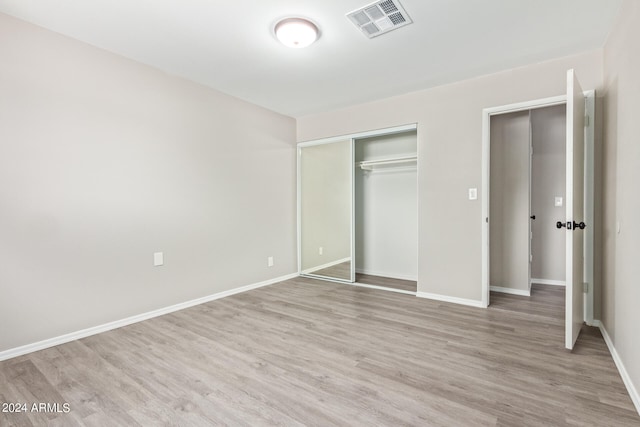 unfurnished bedroom with wood-type flooring and a closet