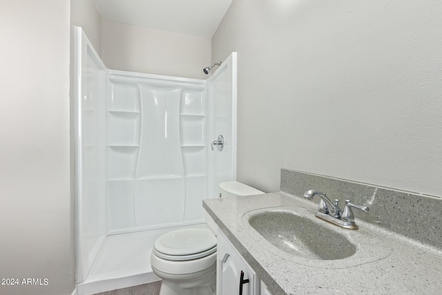 bathroom with walk in shower, vanity, and toilet