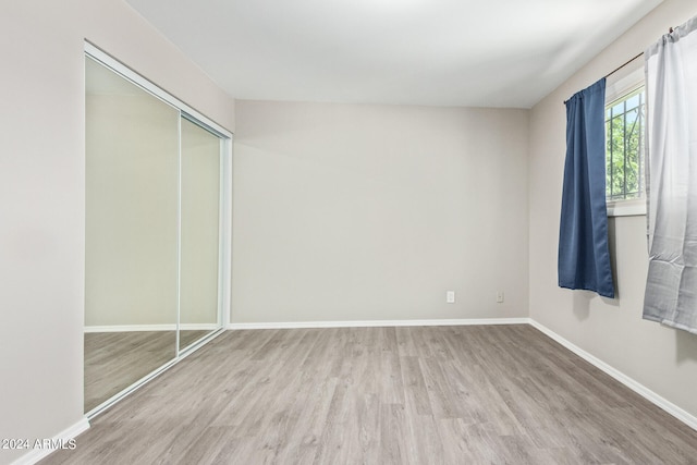 unfurnished bedroom with a closet and hardwood / wood-style floors