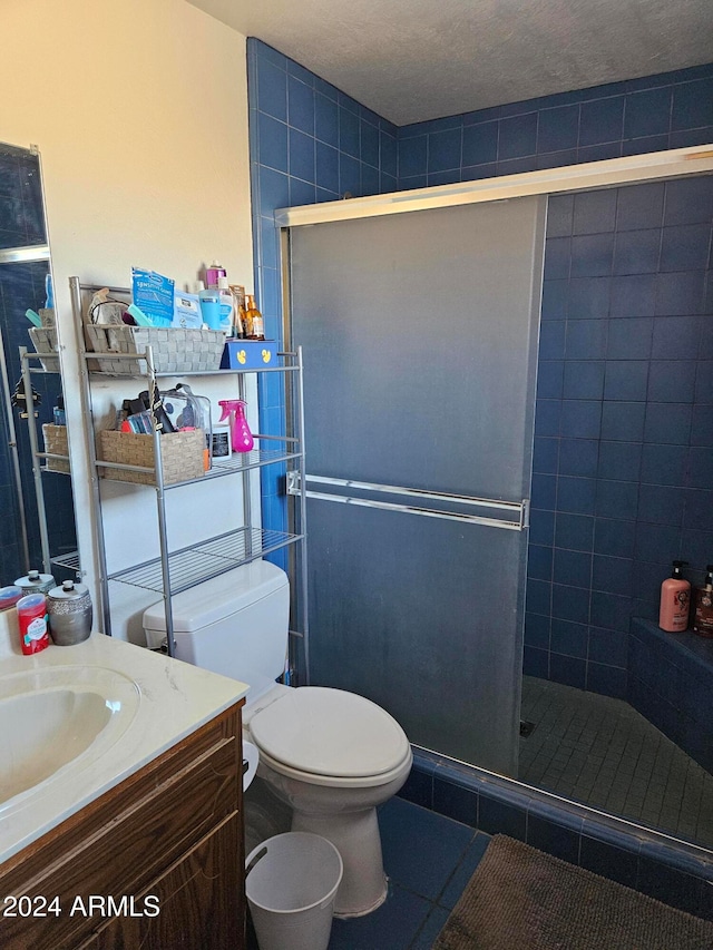 bathroom with vanity, toilet, walk in shower, and a textured ceiling