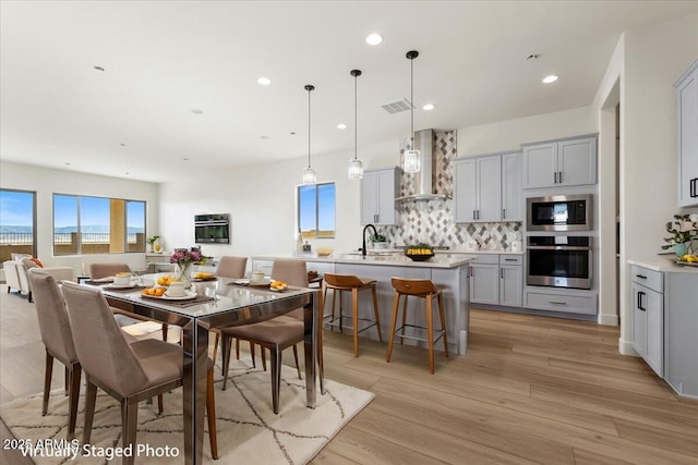 dining area featuring a wealth of natural light, visible vents, light wood finished floors, and recessed lighting