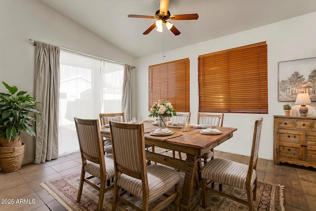 tiled dining space with vaulted ceiling and a ceiling fan