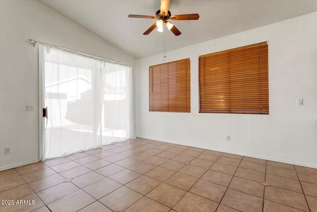 spare room featuring lofted ceiling, light tile patterned floors, a ceiling fan, and baseboards