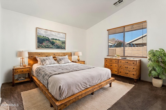 bedroom with lofted ceiling, dark carpet, visible vents, and baseboards