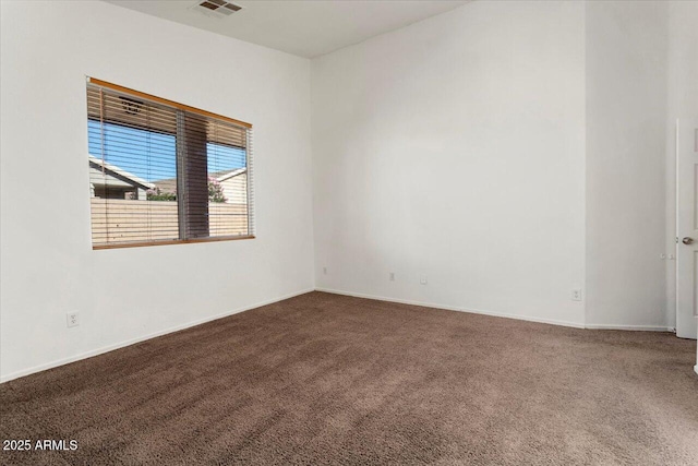 spare room featuring carpet floors, baseboards, and visible vents