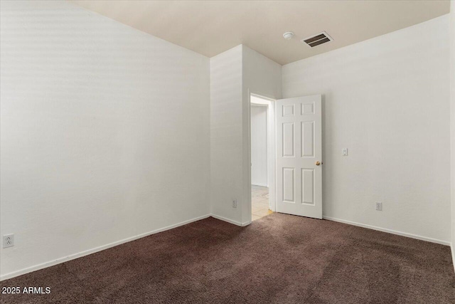 empty room with carpet floors, visible vents, and baseboards