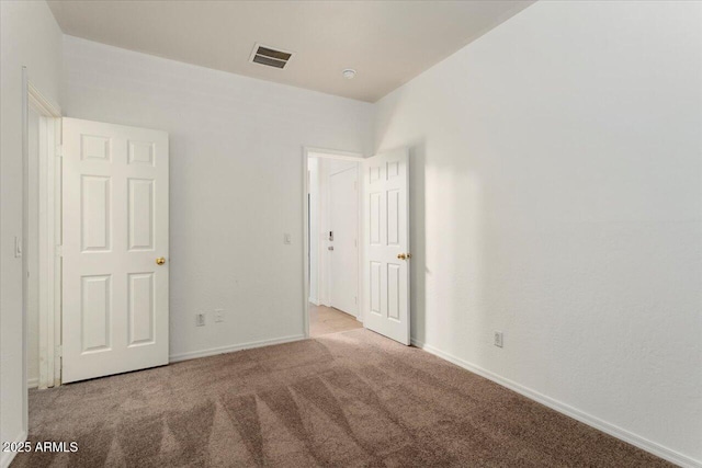 unfurnished bedroom featuring light carpet, baseboards, and visible vents