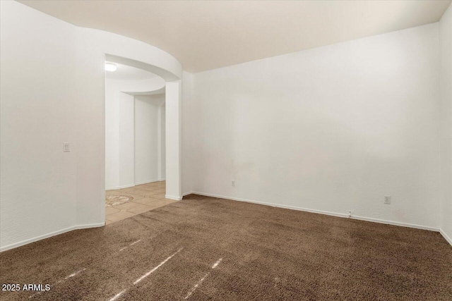 empty room featuring carpet and baseboards