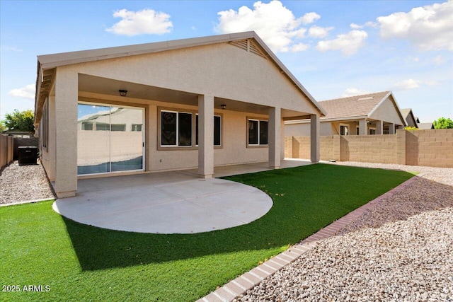 rear view of property featuring a patio area, fence, and stucco siding