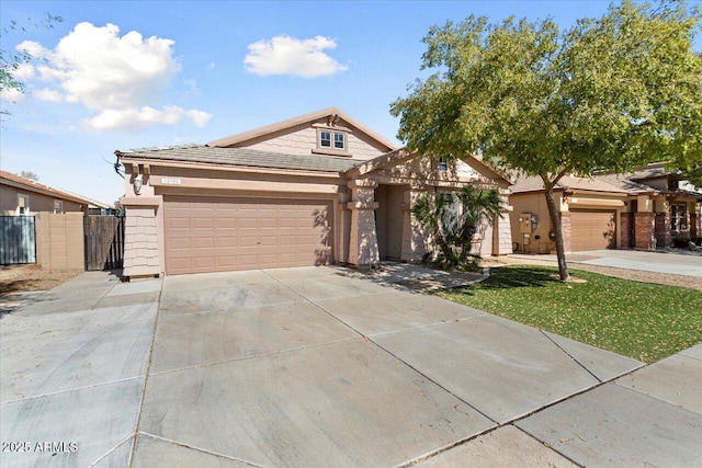 view of front of home with driveway, an attached garage, and fence