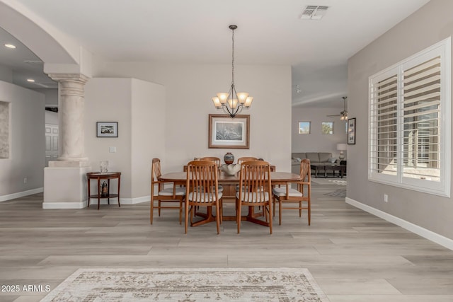 dining area featuring ceiling fan with notable chandelier, light hardwood / wood-style floors, and ornate columns