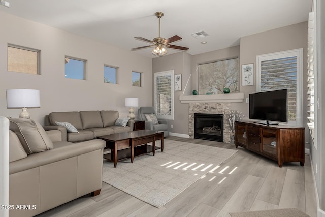 living room featuring ceiling fan, plenty of natural light, and light hardwood / wood-style flooring