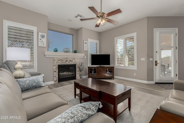 living room featuring ceiling fan, a fireplace, and hardwood / wood-style floors