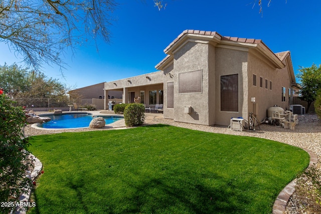 back of property featuring a lawn, central AC unit, a patio area, and a fenced in pool