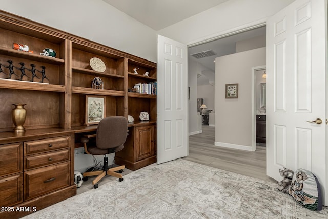 office featuring light wood-type flooring and built in desk