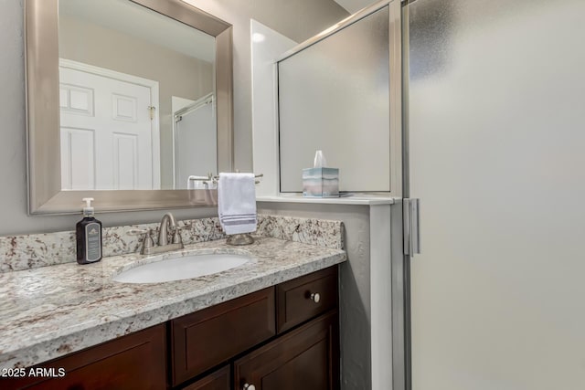 bathroom featuring an enclosed shower and vanity