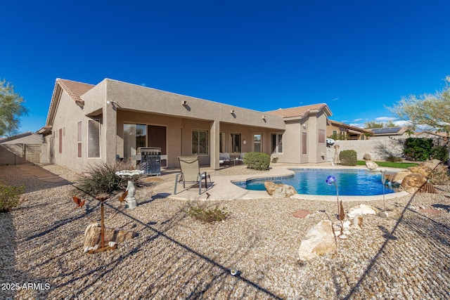 back of house with a fenced in pool and a patio