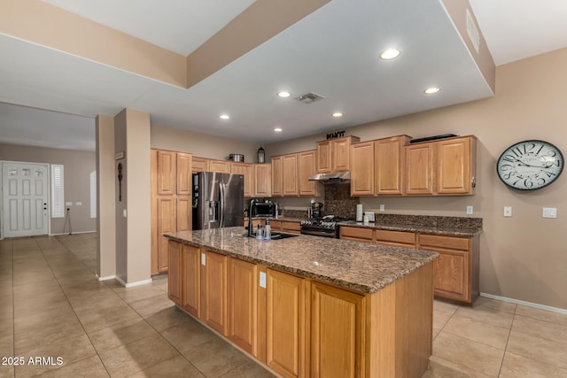 1268 N Pine St, Gilbert, AZ 85233 - kitchen with stainless steel refrigerator with ice dispenser, light tile patterned flooring, under cabinet range hood, black range with gas stovetop, and dark stone counters