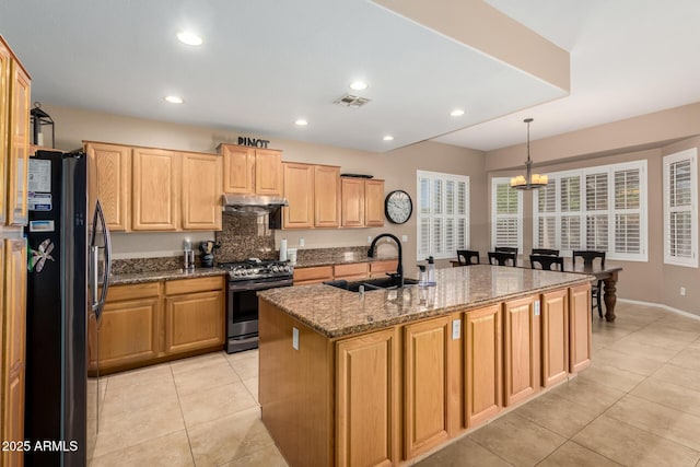1268 N Pine St, Gilbert, AZ 85233 - kitchen with stainless steel gas range, freestanding refrigerator, under cabinet range hood, a chandelier, and light tile patterned flooring