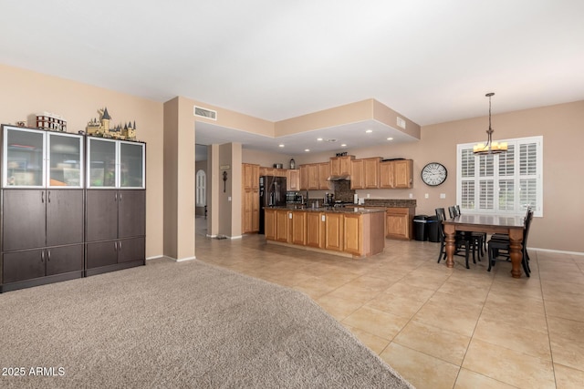 1268 N Pine St, Gilbert, AZ 85233 - kitchen with light tile patterned floors, open floor plan, pendant lighting, black fridge, and an island with sink
