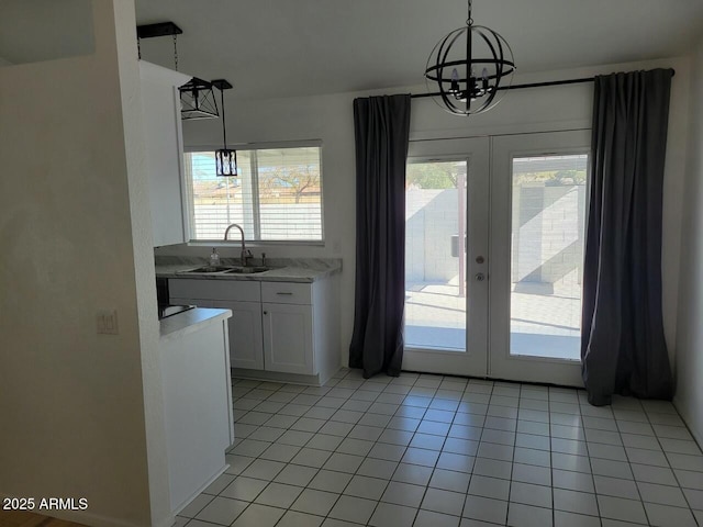 entryway with a healthy amount of sunlight, sink, light tile patterned flooring, and french doors