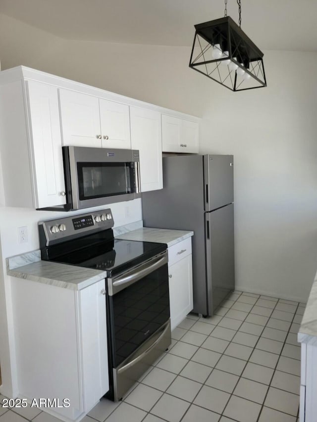 kitchen featuring stainless steel appliances, lofted ceiling, light tile patterned floors, and white cabinets