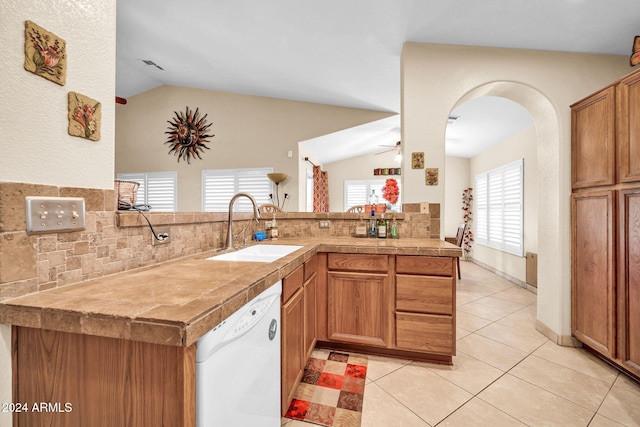 kitchen featuring tasteful backsplash, sink, vaulted ceiling, dishwasher, and kitchen peninsula