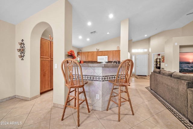 tiled dining space featuring lofted ceiling