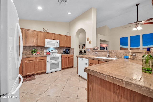 kitchen featuring sink, kitchen peninsula, ceiling fan, light tile patterned floors, and white appliances