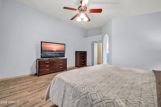 bedroom with ceiling fan, lofted ceiling, and light hardwood / wood-style floors