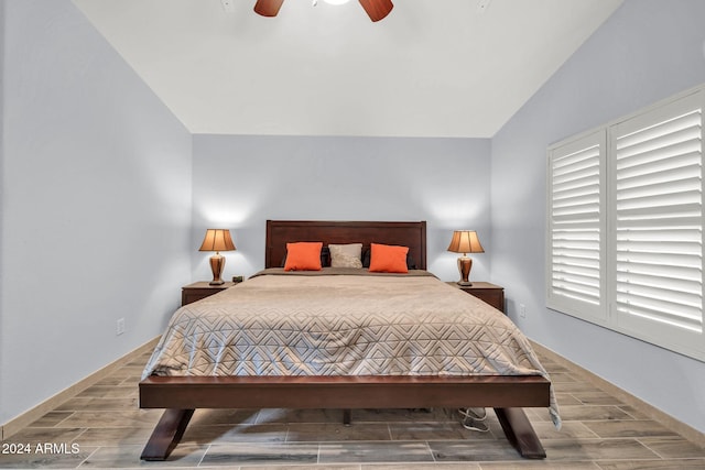 bedroom with hardwood / wood-style floors, vaulted ceiling, and ceiling fan