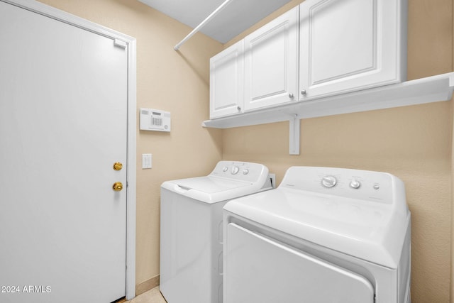 laundry room featuring cabinets and washing machine and clothes dryer