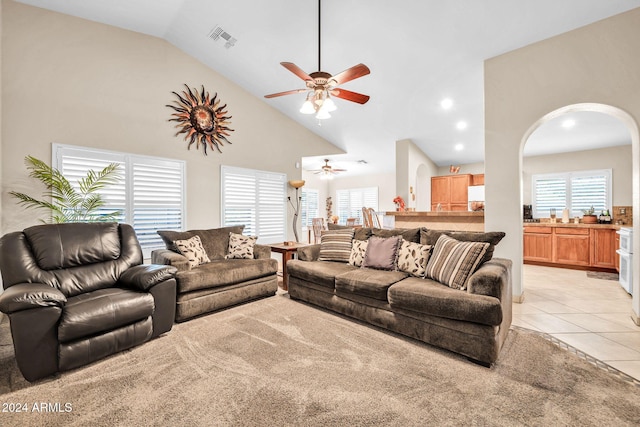 tiled living room with ceiling fan and high vaulted ceiling