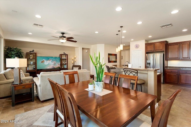 dining area with ceiling fan and sink