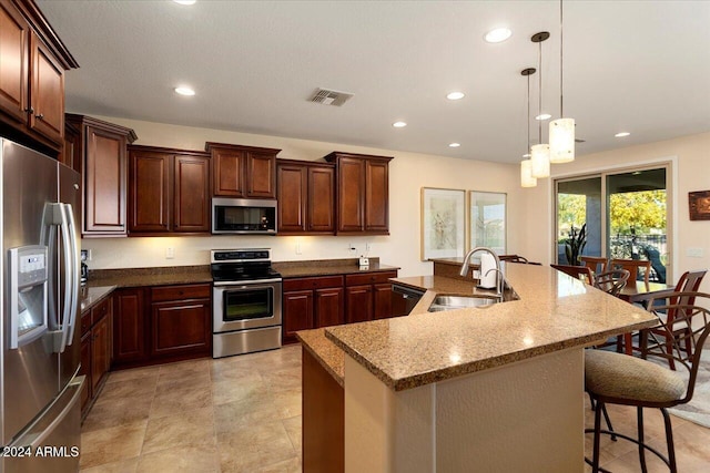 kitchen featuring sink, hanging light fixtures, a breakfast bar area, a large island, and stainless steel appliances