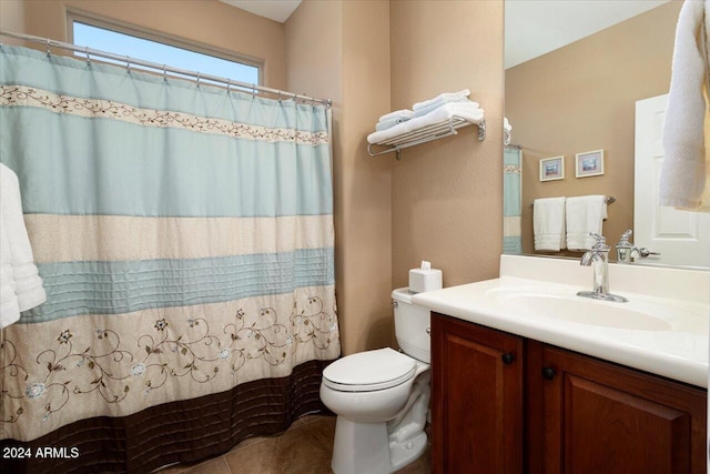 bathroom featuring tile patterned flooring, vanity, toilet, and curtained shower