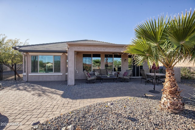 rear view of property featuring a patio area and an outdoor living space