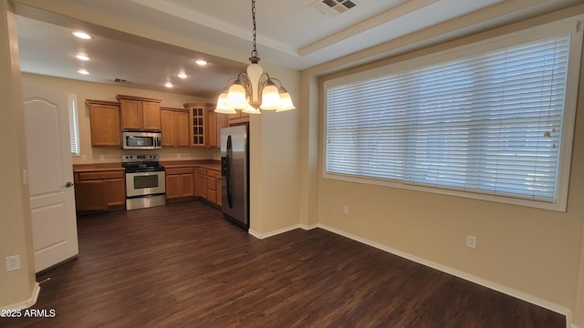 kitchen with dark wood-style flooring, brown cabinets, stainless steel appliances, visible vents, and hanging light fixtures