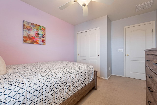 bedroom with ceiling fan, a closet, and light carpet