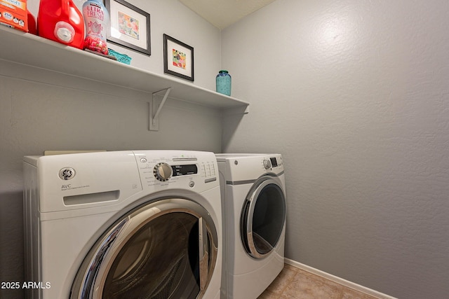 laundry room with washing machine and dryer and light tile patterned flooring