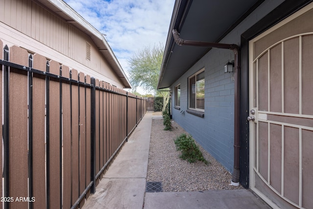 view of side of home featuring brick siding and fence