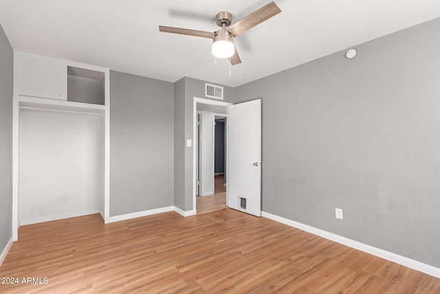 unfurnished bedroom featuring ceiling fan, a closet, and light hardwood / wood-style flooring