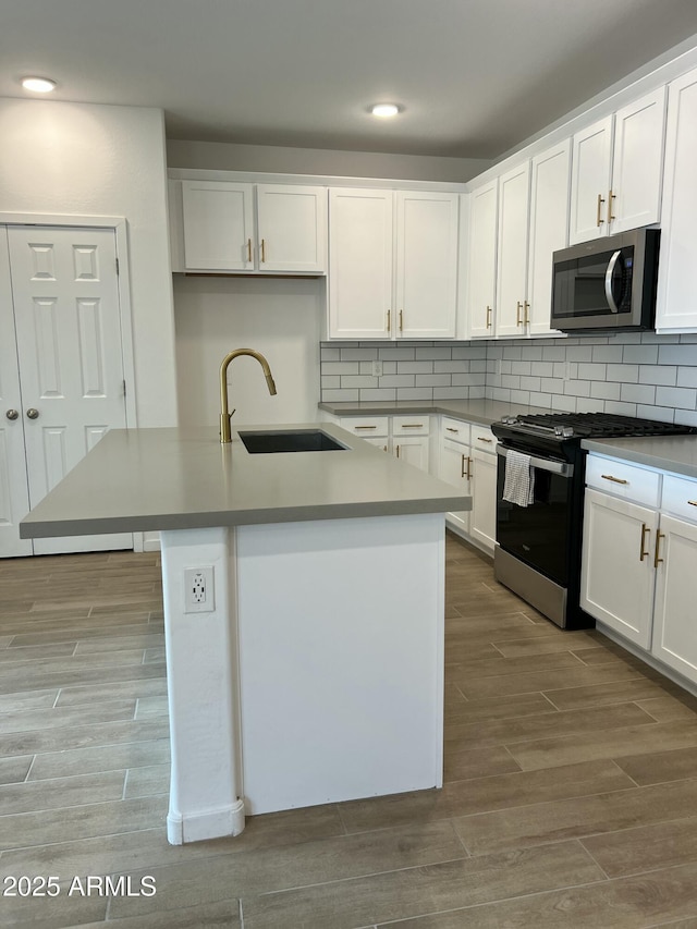 kitchen featuring white cabinetry, sink, light hardwood / wood-style floors, and appliances with stainless steel finishes