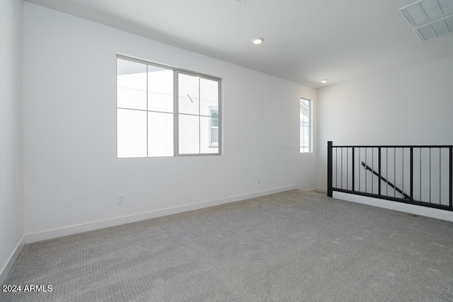 unfurnished room with light colored carpet and a healthy amount of sunlight