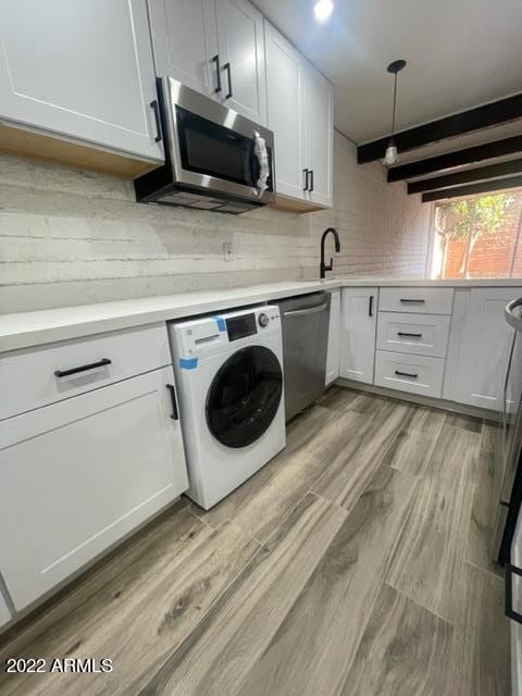 clothes washing area featuring washer / clothes dryer, sink, and light hardwood / wood-style flooring