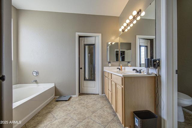6811 W Darrel Rd, Laveen, AZ 85339 - bathroom featuring double vanity, a garden tub, toilet, tile patterned flooring, and baseboards