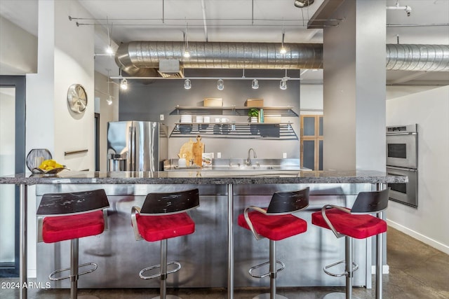 kitchen featuring stainless steel appliances and a breakfast bar area