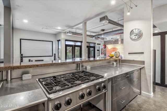 kitchen with cooktop, french doors, concrete floors, and stainless steel counters